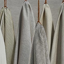 A collection of grey textured soft fabrics, hanging artfully on some twine.
