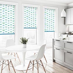 A green and blue dragonfly roller blind is shown in a clean, neutral kitchen/dining area.
