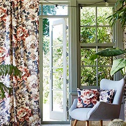 A floral velvet curtain, in purple and red hung in a stylish orangery.