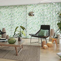 A green, multicoloured Vertical blind is shown in a modern room, covering a large glass window.