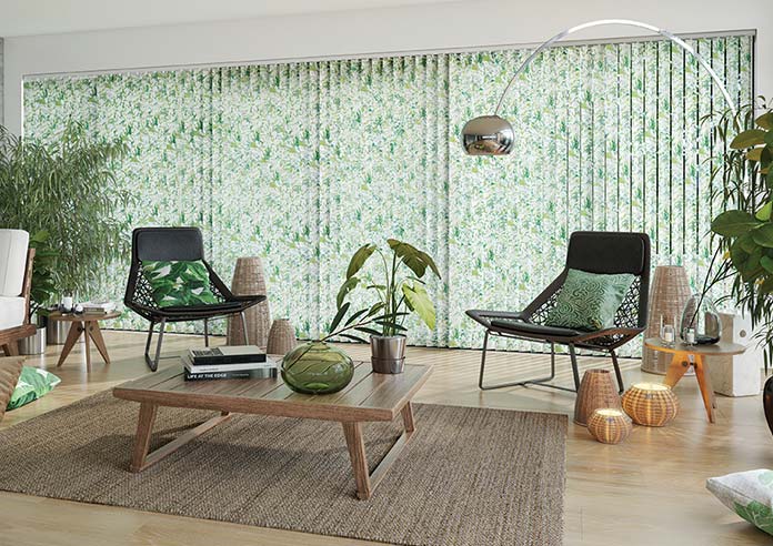 A green, multicoloured Vertical blind is shown in a modern room, covering a large glass window.
