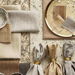 An array of gold, silver and bronze soft fabrics, are artistically lain out.