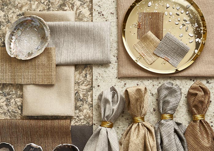An array of gold, silver and bronze soft fabrics, are artistically lain out.