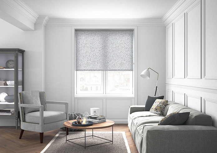 A spotty black and white roller blind in a neutral living room