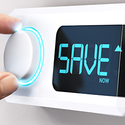 A hand altering a thermostat