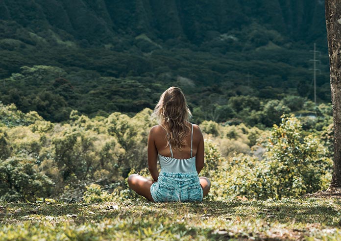 A woman meditating on grassland