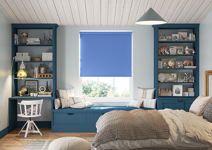 A bedroom is shown with a azure blue roller blind adoring the window.