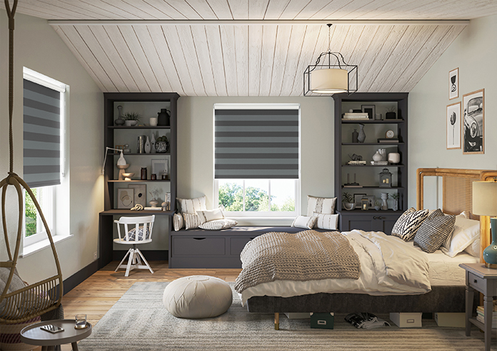 A striped grey roller blind is shown in a bedroom, decorated in a teen-style look.