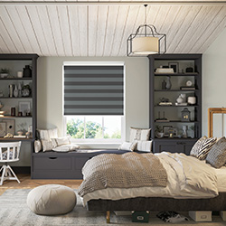 A striped grey roller blind is shown in a bedroom, decorated in a teen-style look.