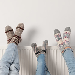 An image showing a family warming their feet on a radiator