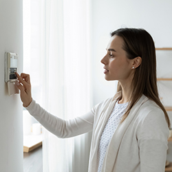 Side view of a young woman using smart home system