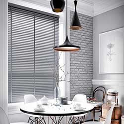 A kitchen is shown is a large window. Grey is the colour scheme. A wide grey wooden blind is shown on the window.
